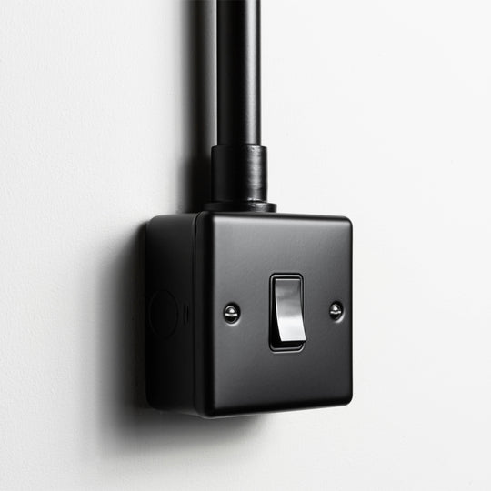 Matt Black Intermediate Switch With Back Box And Conduit On A Light Grey Background