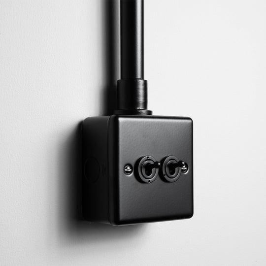 Matt Black 2 Gang 2 Way Toggle Switch With Back Box And Conduit On Light Grey Background