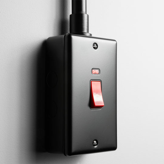 Matt Black 2 gang 45A Double Pole Switch  With Back Box And Conduit On A Light Grey Background