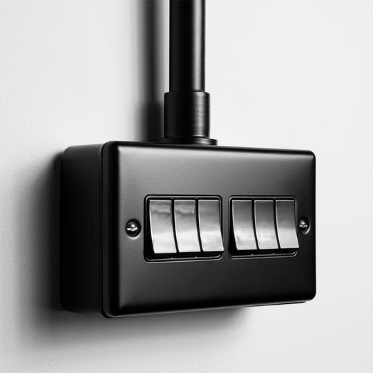 Matt Black 6 Gang 2 Way Switch With Black Insert With Back Box And Conduit On Light Grey Background