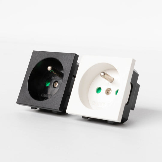 A black and white French socket module with a round earth grounding pin and a switch lever.