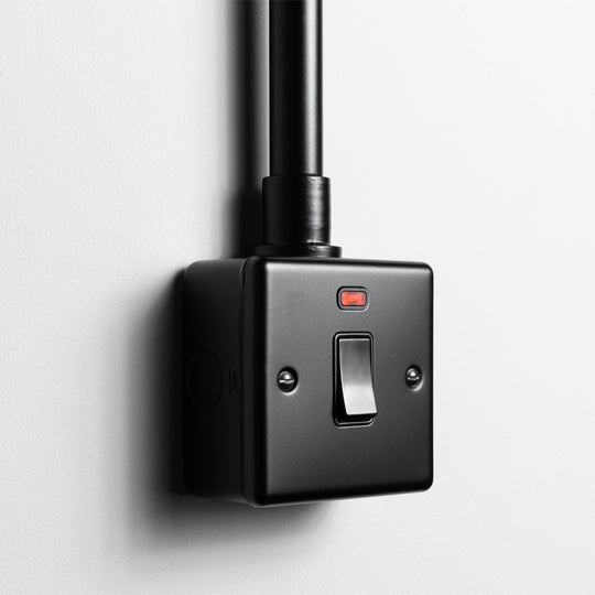 Matt Black 20A Double Pole Switch with Neon With Back Box And Conduit On A Light Grey Background