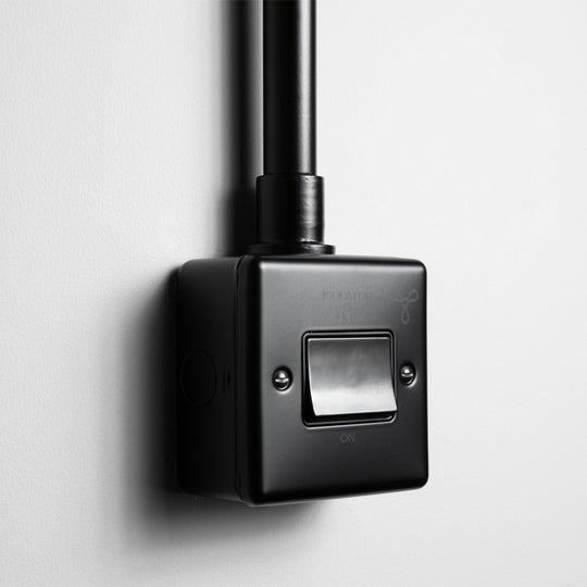 Matt Black 6A Fan Switch With Back Box And Conduit On A Light Grey Background