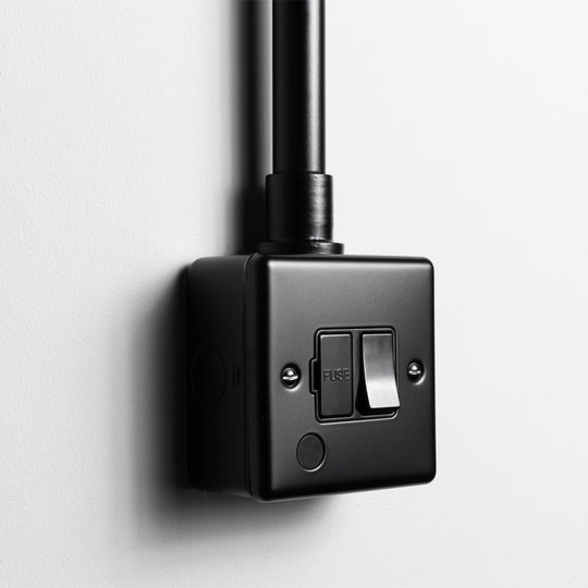 Matt Black Switched Fused Connection Switch With Flex Outlet With Black Insert With Back Box And Conduit On Light Grey Background