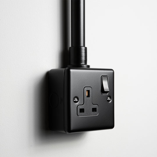 Matt Black Single Socket With Back Box And Conduit On A Light Grey Background