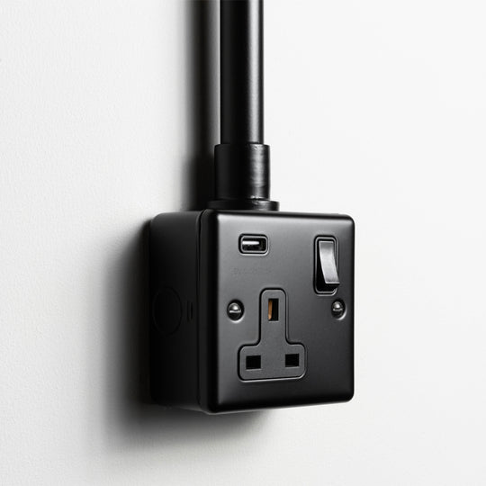 Matt Black Single Socket With USB With Back Box And Conduit On A Light Grey Background