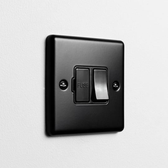 Matt Black Switched Fused Connection Switch On A Light Grey Background