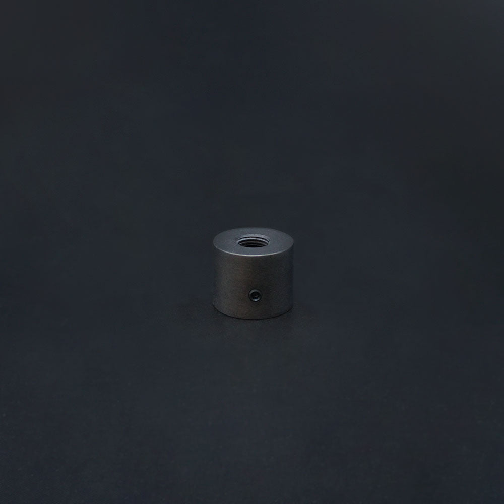 A dark bronze conduit adaptor made from solid brass, displayed against a dark background.