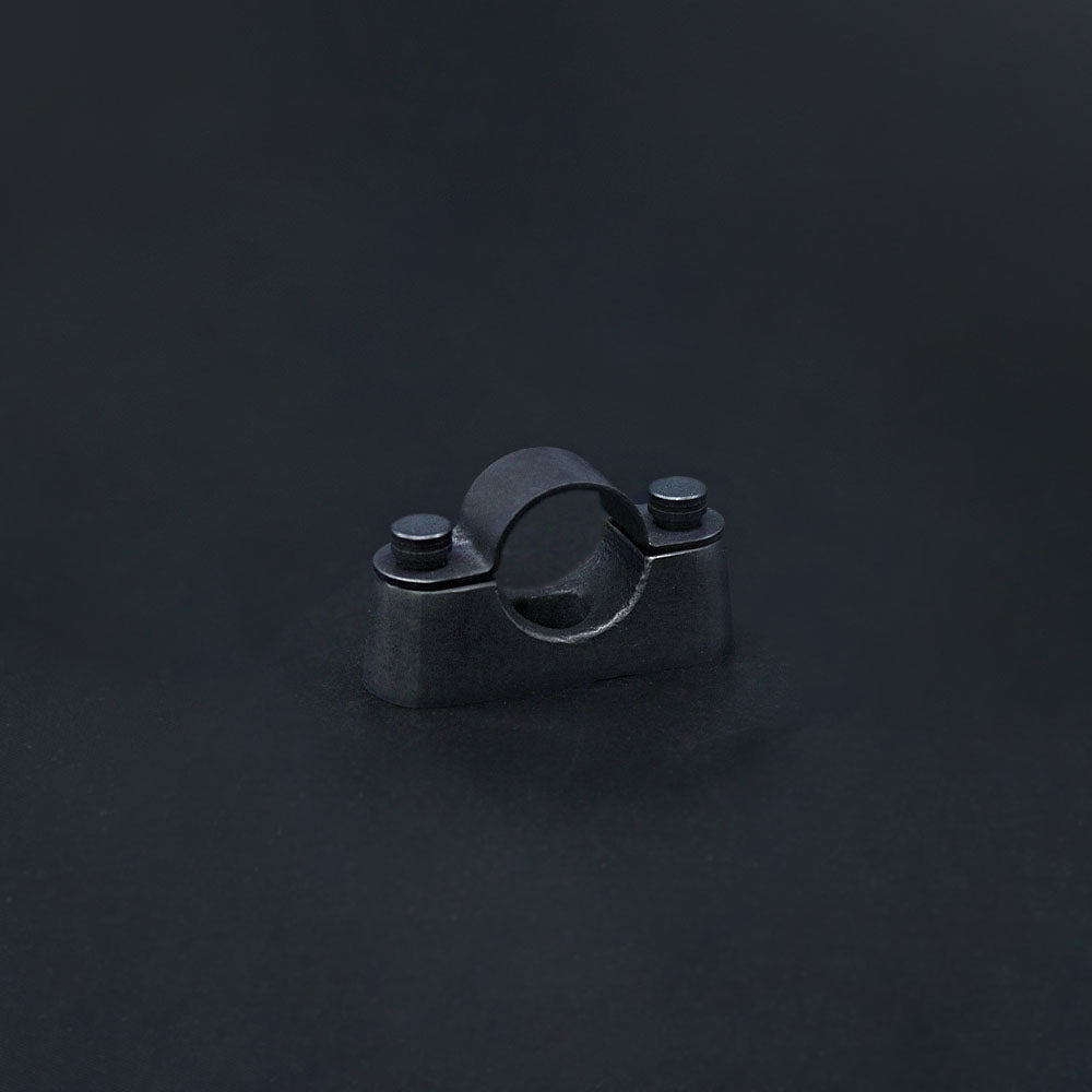A dark bronze conduit saddle with a solid brass base and top strap, featuring matching knurled head M4 fixing screws, against a dark background.