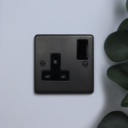 A dark bronze single socket outlet against a light background