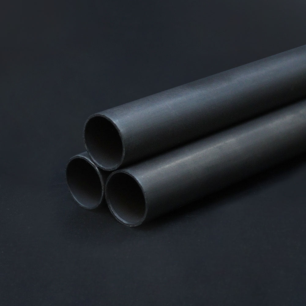 Three pieces of dark bronze conduit arranged parallel to each other on a dark background.