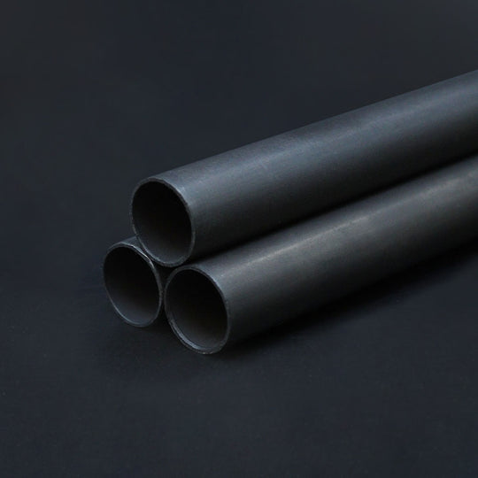 Three pieces of dark bronze conduit arranged parallel to each other on a dark background.