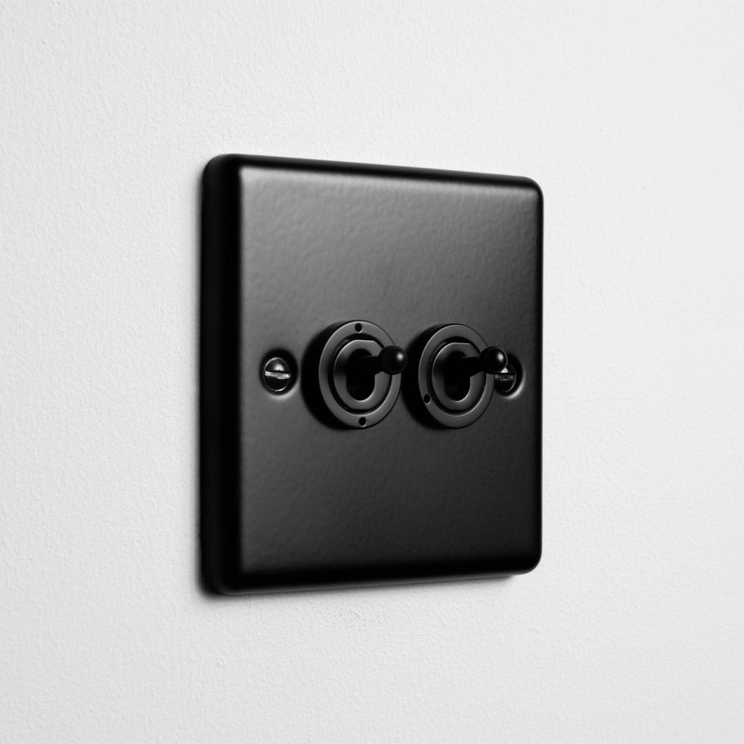 Matt Black 2 Gang 2 Way Toggle Switch On Light Grey Background