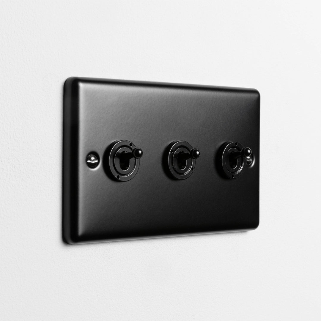 Matt Black 3 Gang 2 Way Toggle Switch On Light Grey Background