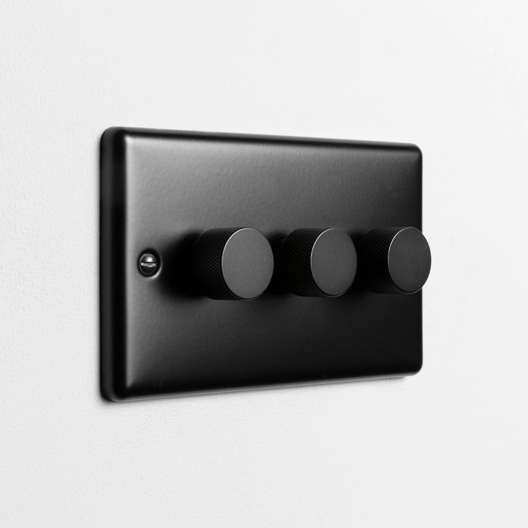 Matt Black 3 Gang 2 Way LED Dimmer Switch On A Light Grey Background