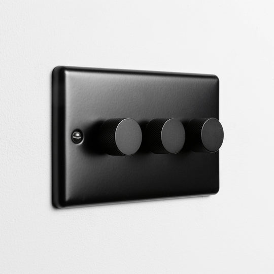 Matt Black 3 Gang 2 Way LED Dimmer Switch On A Light Grey Background