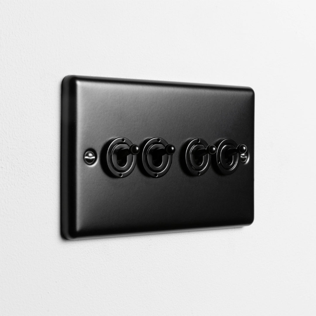 Matt Black 4 Gang 2 Way Toggle Switch On Light Grey Wall