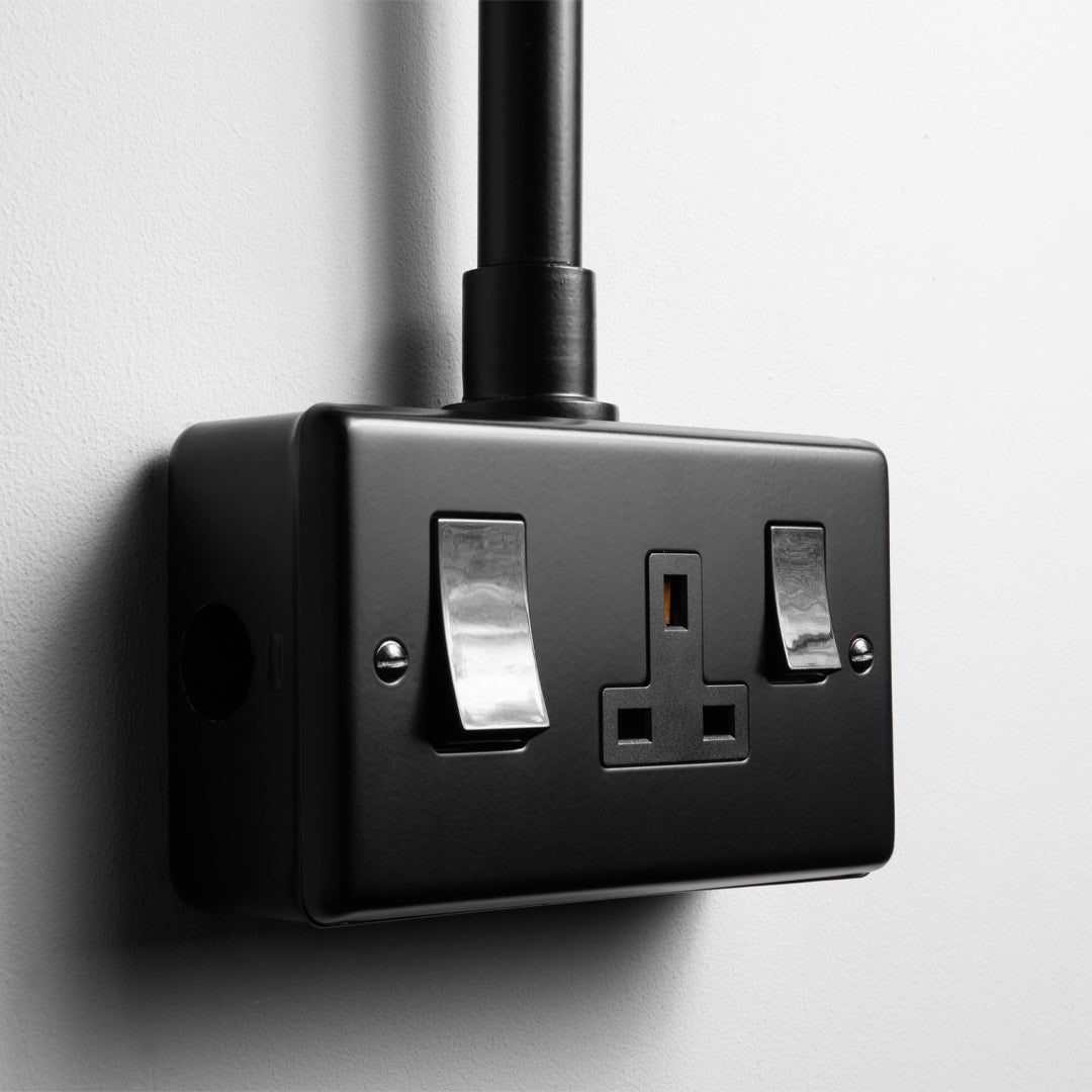 Matt Black 45A Cooker Switch with Socket With Back Box And Conduit On A Light Grey Background