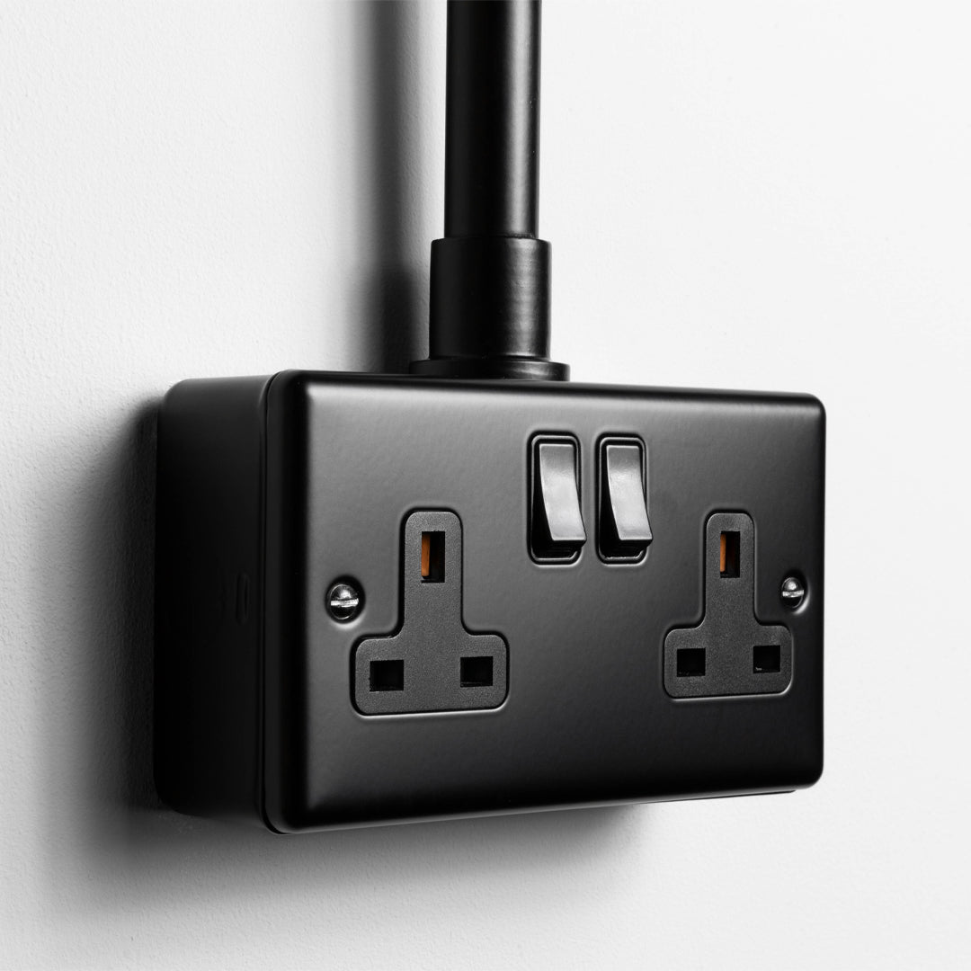 Matt Black Double Socket With Back Box And Conduit On A Light Grey Background