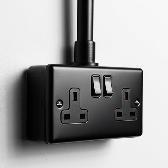 Matt Black Double Socket With Back Box And Conduit On A Light Grey Background