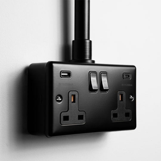 Matt Black Double Socket With USB A & C With Black Insert With Back Box And Conduit On Light Grey Background