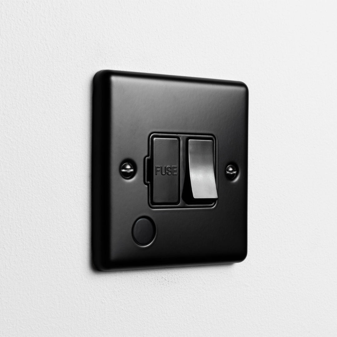 Matt Black Switched Fused Connection Switch With Flex Outlet With Black Insert On Light Grey Background