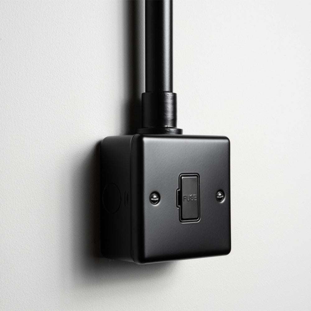 Matt Black Unswitched Fused Connection Switch With Back Box And Conduit On A Light Grey Background