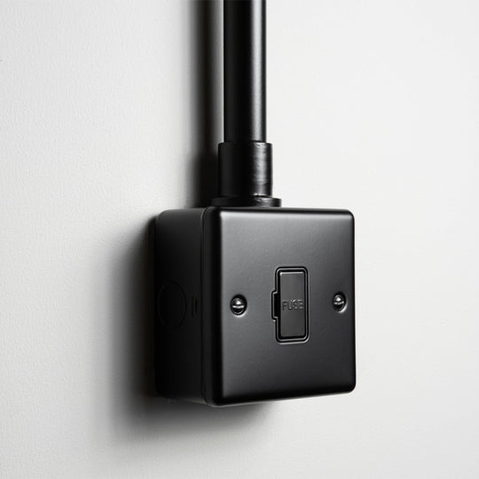Matt Black Unswitched Fused Connection Switch With Back Box And Conduit On A Light Grey Background
