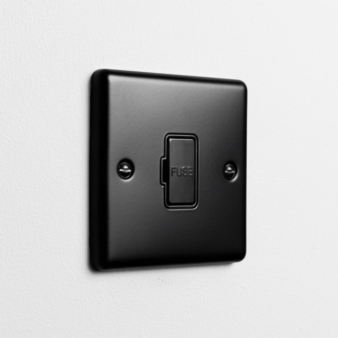 Matt Black Unswitched Fused Connection Switch On A Light Grey Background